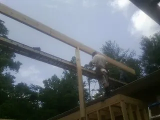 Carpenter setting a ridge beam over a new addition frame — Ice Dam Removal by Roofing Brothers in Indio