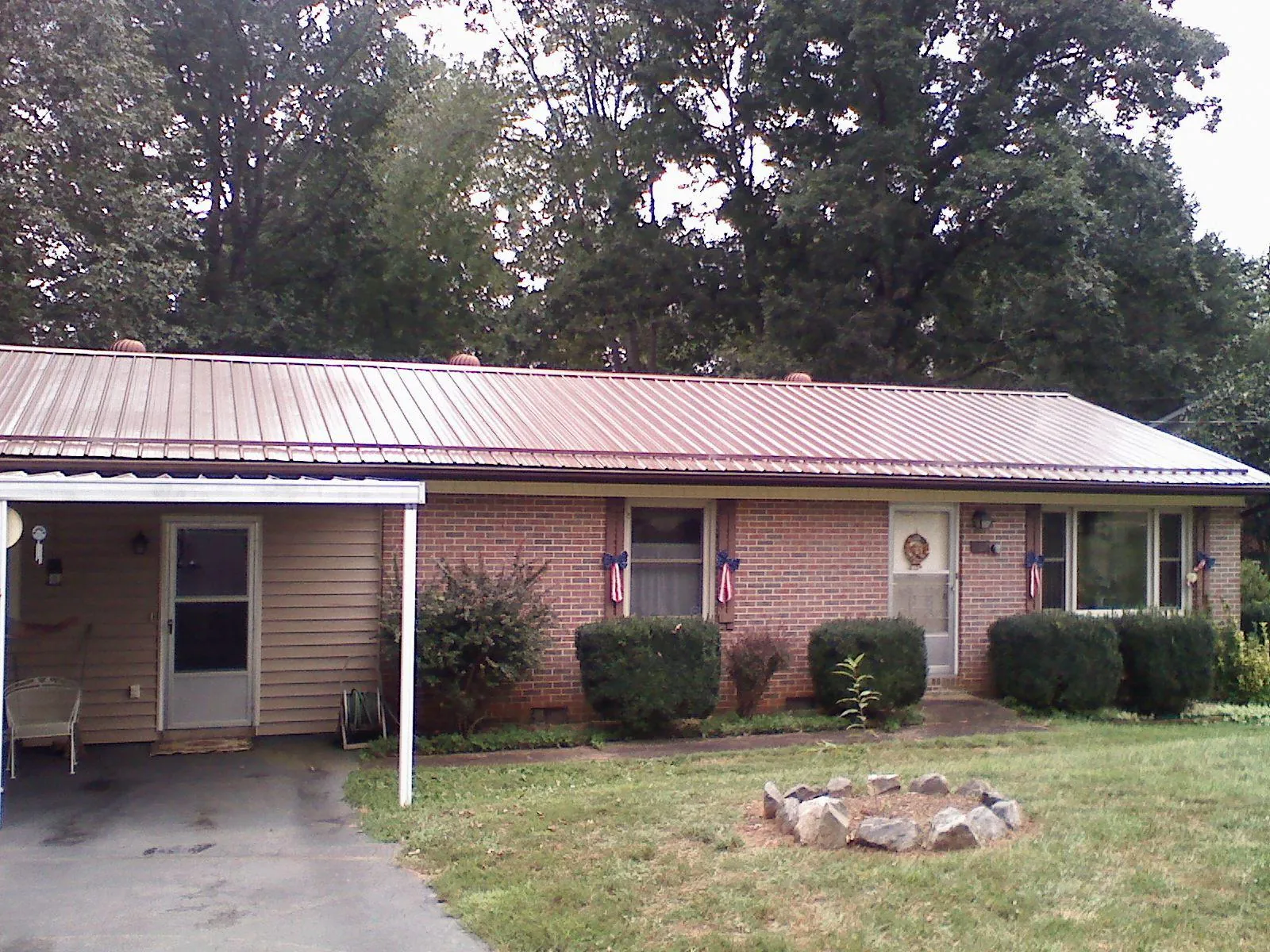 Bronze metal roof and carport on a brick ranch home — Roof Repair work by our crew in Indio